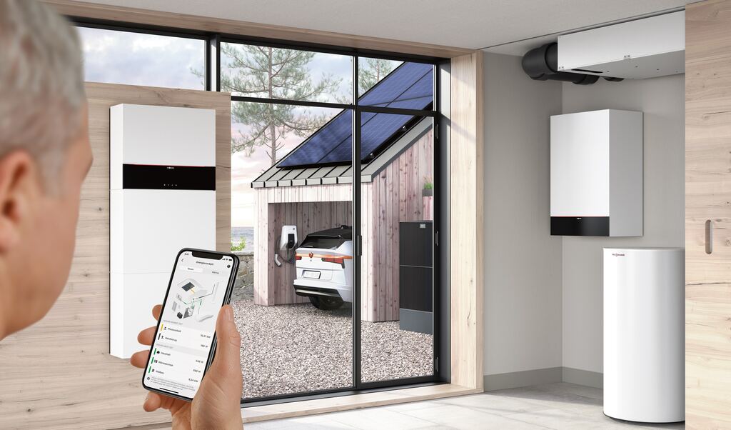 Hauswirtschaftsraum mit Viessmann-Stromspeicher, Smartphone mit Energie-App, Carport mit Solardach, Ladestation und Wärmepumpe